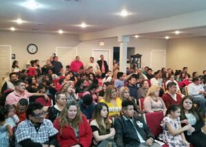 A small worship space with full chairs and standing room only.